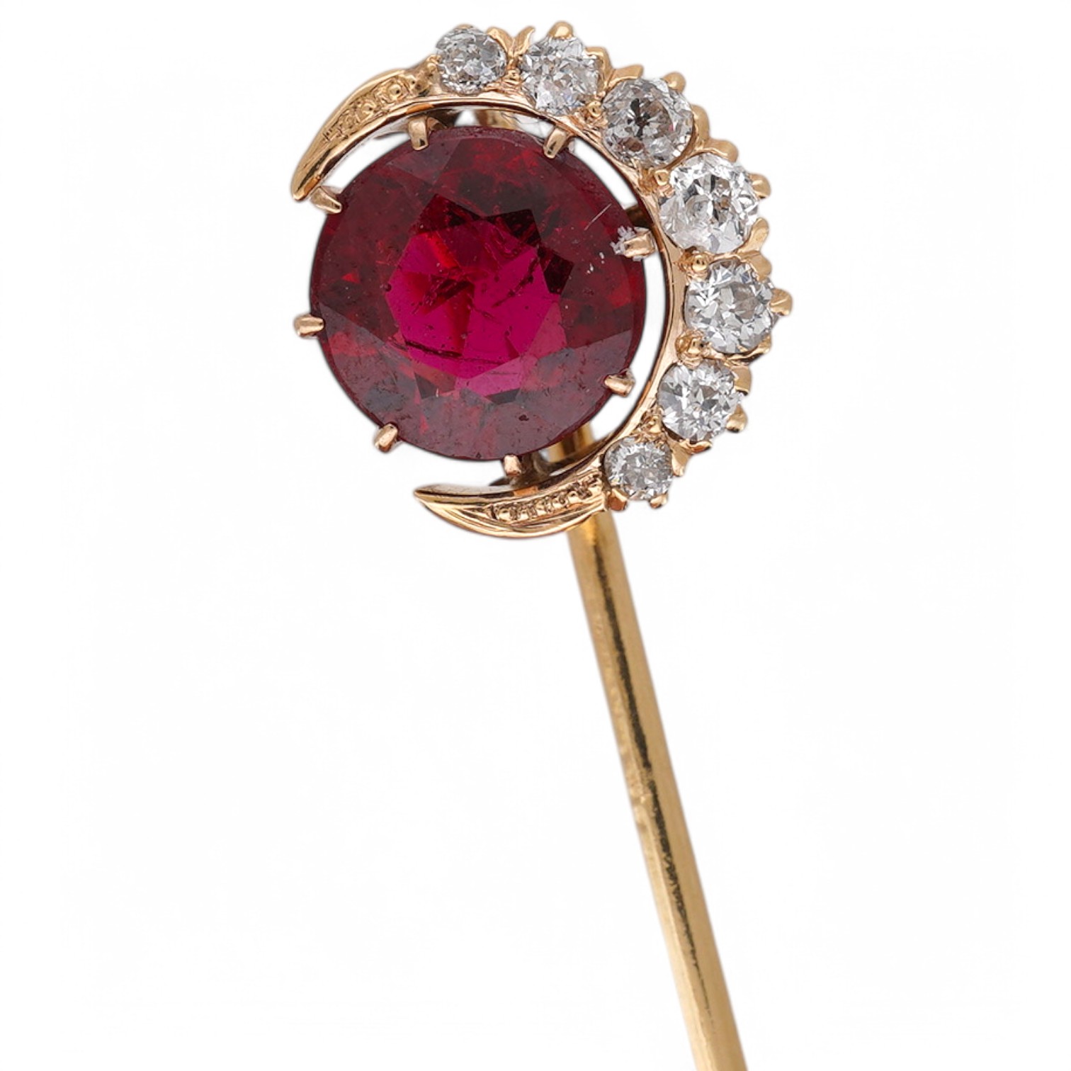 An early to mid 20th century yellow metal and single stone garnet topped doublet set stick pin, with diamond set crescent border, 61mm, gross weight 2.9 grams. Condition - fair to good